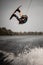 active man doing extreme high jump on wakeboard over splashing river wave