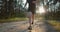 Active man jogging on sandy road among green trees