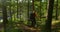 Active man with large backpack walks down steep mountain path at sunset