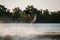 active man making trick in jump time with wakeboard and many splashes around