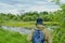 Active man in mosquito suit with backpack in hiking near forest lake in siberia, russia