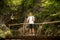 Active man resting on a bridge over mountain creek