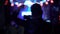 Active man shaking hand and filming live show at night club, dancing people