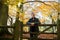 Active Mature Man Leaning On Wooden Gate On Walk Through Autumn Woodland