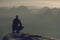 Active midle age tourist or runner sits on the edge of a rock