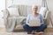 Active old woman sitting on floor and using laptop