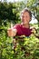 Active older man in garden holds thumb up