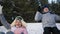active pensioners, joyful old man and woman have fun sledding down snowy hill in forest in sunny weather during a