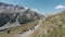 Active people walking up on the mountain trail. Clip. Group of hikers exploring breathtaking summer trail on rocks and