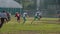 Active players and referee running fast on gridiron, American football match