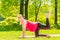 Active pregnant girl is engaged in gymnastics in the park