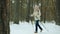Active retired woman enjoying nordic ski walking in winter wood looking around smiling