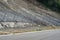 Active robust rockfall barrier system with wire mesh along the road, brake for rocks fall.