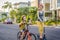 Active school kid boy and his mom in safety helmet riding a bike with backpack on sunny day. Happy child biking on way