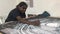 Active senior Aboriginal woman artist dot painting