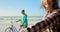 Active senior Caucasian couple standing with bicycle on the beach 4k