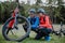 Active senior couple mending bicycle outdoors in forest in autumn day.