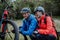 Active senior couple mending bicycle outdoors in forest in autumn day.