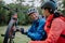Active senior couple mending bicycle outdoors in forest in autumn day.