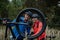 Active senior couple mending bicycle outdoors in forest in autumn day.