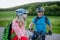 Active senior couple riding electric bicycles on road at summer park, healthy lifestyle concept.