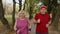 Active senior elderly couple doing cardio morning exercise workout. Man, woman running in city park.