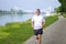 Active senior man jogging along the bank of a river in spring