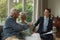 Active senior man shaking hands with real estate agent in living room