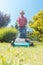 Active senior man smiling while using a grass cutting machine in the garden