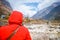 Active senior nepalese beautiful woman in red winter jacket looking at mountain and blue sky background. Relaxing moment Waiting