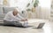 Active Senior Woman Doing Warming Stretching Exercises In Front Of Laptop