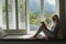 Active senior woman reading a book on window seat