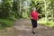 Active senior woman running at forest jogging track