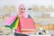 Active smart asian muslim woman in jean jacket standing and holding shopping bags with online package box delivery background.