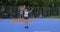 Active smiling teenage girl, fashionable with purple hair, jumping on street basketball court with arms raised