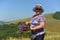 Active smiling woman pensioner collects wild flowers in the mountains