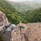 Active sporty woman relaxing in nature, practicing yoga on high clif by 500 feet waterfall at Black river gorges