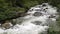 Active strong current of the big river. The flow of water and large stones. Mountain river in Altai. Hike in the Altai reserve