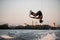 active strong man rider holds rope and making extreme jump showing trick on wakeboard.