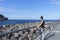 Active teenager calmness looking to the sea standing in front of a breakwater harbor ready to run