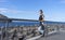 Active teenager calmness looking to the sea standing in front of a breakwater harbor ready to run