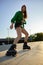 Active teenager girl rollerskater riding at outdoor rollerdrom