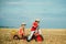 Active toddler kid playing and cycling outdoors. Two Kids having fun in field against blue sky background. Earth day