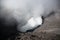 Active volcano crater with smoke