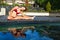 Active woman in bikini stretching at poolside to keep fit