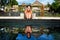 Active woman in bikini stretching at poolside to keep fit