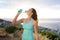 Active woman drinking from water bottle in front of the sea