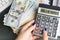 Active woman planning early retirement with calculating machine and her savings for pension