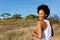 Active woman runner standing in the field and laughing