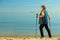 Active woman senior nordic walking on a beach